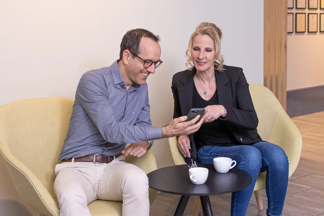 Zwei Mitarbeitende von RUEPP & Partner schauen gemeinsam auf ein Smartphone