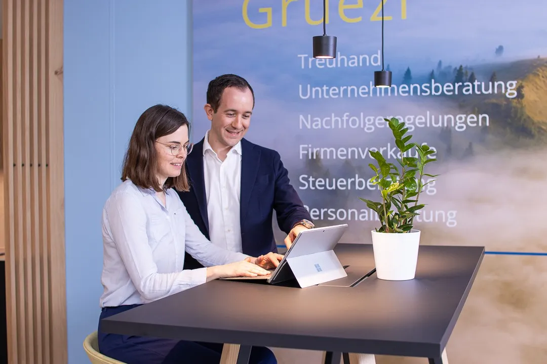 Lukas Müller mit einer Mitarbeiterin an einem Stehtisch im Büro der RUEPP & Partner AG